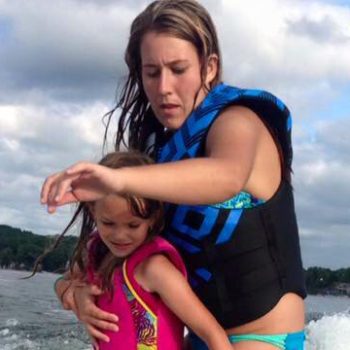 A woman and a young girl enjoying a thrilling moment together while water skiing on a sunny day.