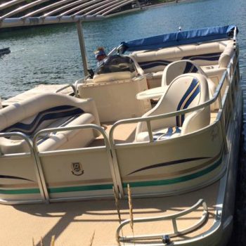 A pontoon boat is securely parked at the dock