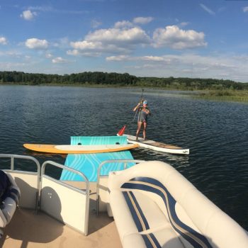 A person balances on a paddle board, surrounded by calm water, enjoying a serene day outdoors.