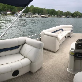 A boat's interior displaying comfortable seating and a steering wheel