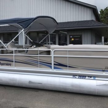 A pontoon boat is docked in front of a building