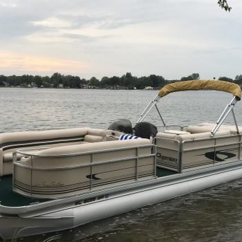 A pontoon boat featuring two seats and a protective canopy, ideal for leisurely outings on the water.