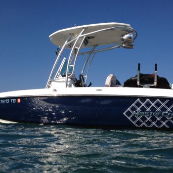 A blue and white boat gently floats on calm waters, reflecting the serene sky above.